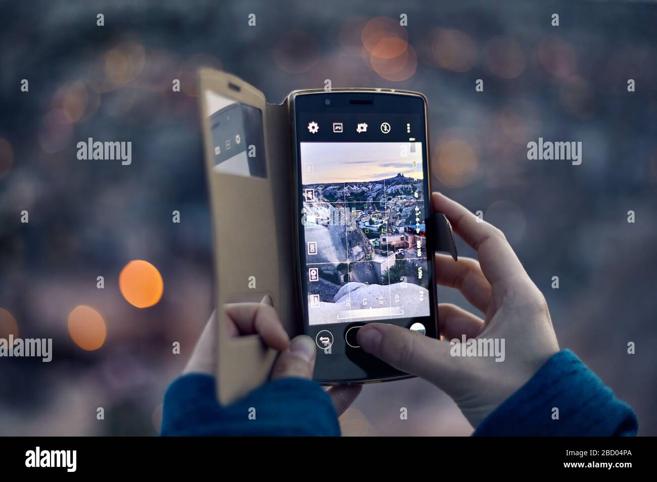 Reisende Frau, die sich bei der Dämmerung auf ihrem Handy in Kappadokien in der Türkei von der Burg Uchisar fotografiert Stockfoto