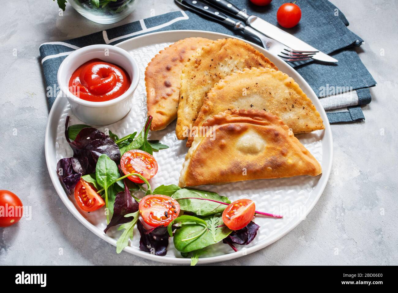 Lateinamerikanische, mexikanische und chilenische Küche. Traditionelle Backwaren Empanadas mit Rindfleisch auf Betongrund Stockfoto