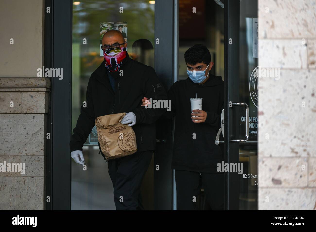 Ein Mann verlässt ein Chipotle-Restaurant, während er eine Facemark und Handschuhe in der Nähe des Ontario Mills Mall, Samstag, 4. April 2020, in Ontario, Kalifornien, USA trägt. (Foto von IOS/Espa-Images) Stockfoto