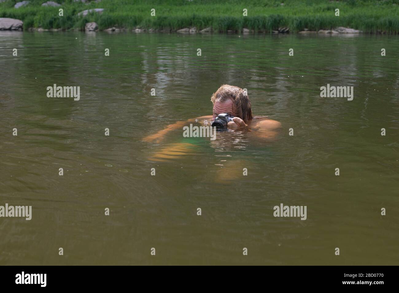 Fotograf Der Die Kamera Am Fluss Schwimmt Und Nur Mit Dem Kopf Uber Dem Wasser Versucht Interessante Aufnahmen Zu Machen Professionelles Jobkonzept Fur Fotografen Stockfotografie Alamy