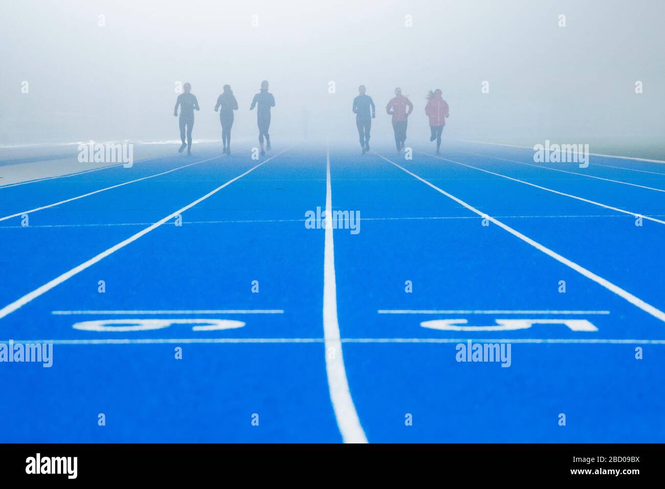 Gruppe von Profisportlern am nebligen Morgen - Leichtathletik Stockfoto