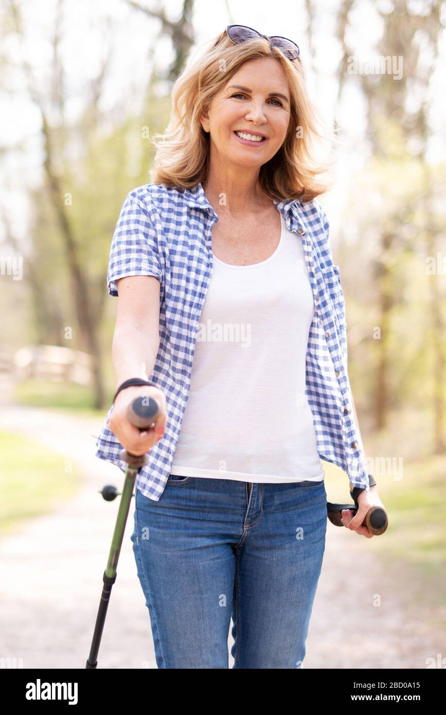 Eine attraktive Frau mit einem sympathischen Lachen in der Natur beim Gehen Stockfoto