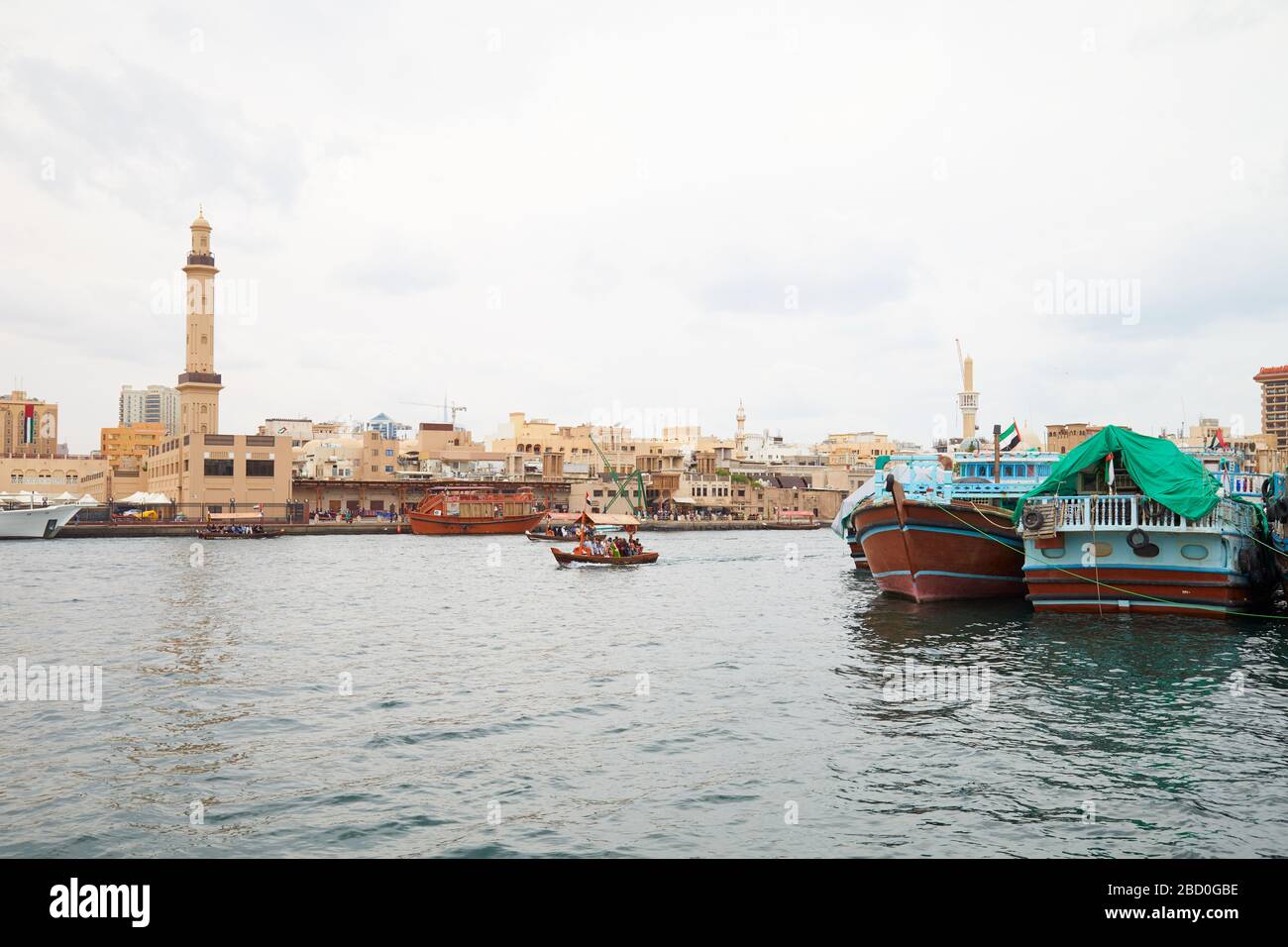 DUBAI, VEREINIGTE ARABISCHE EMIRATE - 21. NOVEMBER 2019: Dubai Creek mit Abra und Dhow traditionelle Boote an einem trübem Tag Stockfoto