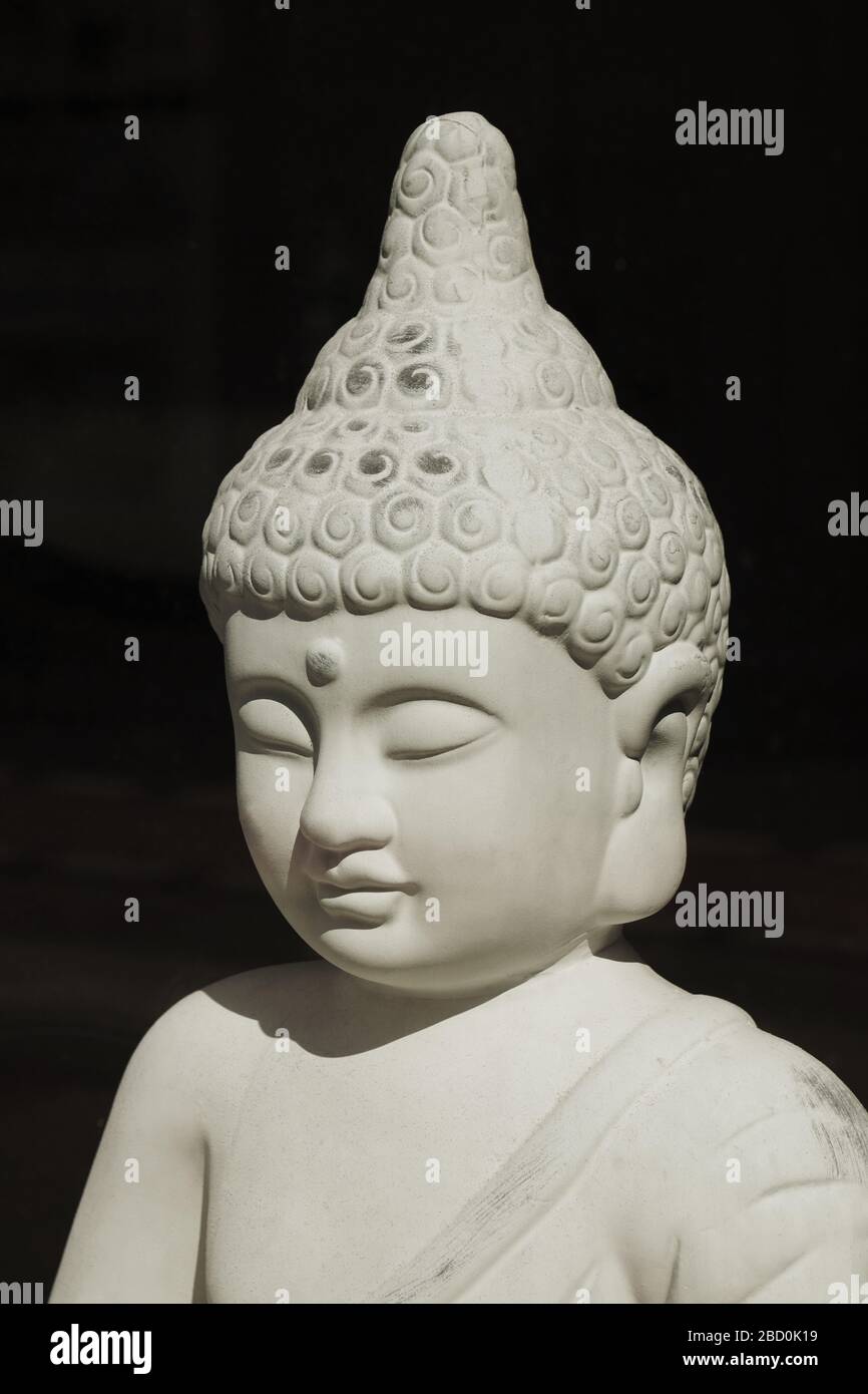 Dekorative buddhastatue in direkter Sonneneinstrahlung - buddhismus Meditationsaufklärung Glauben und Spiritualität Konzept Stockfoto
