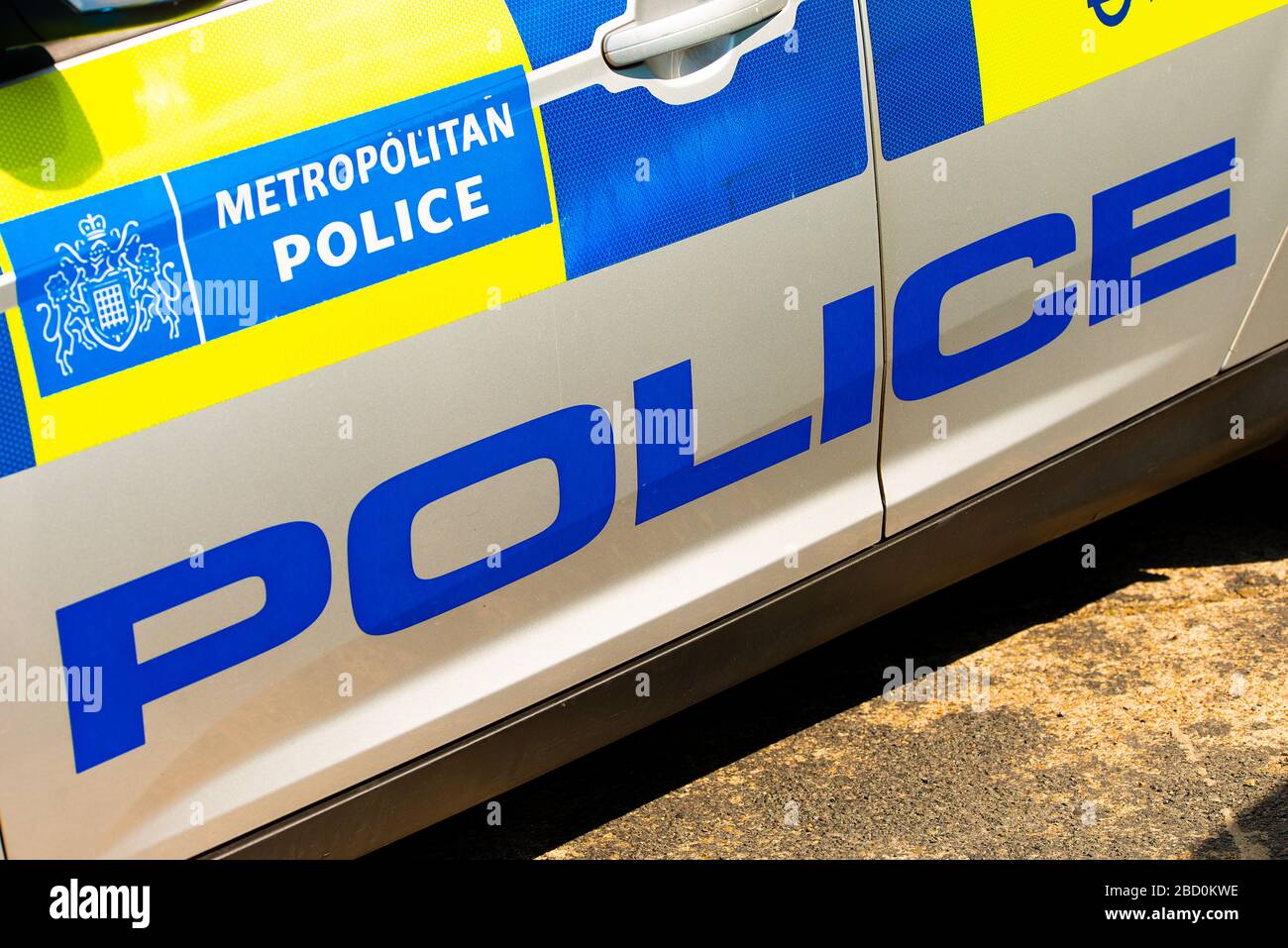 Angewinkelte Ansicht des Metropolitan Police Hinweisschildes an der Seitentür des Schnelleingreif-Patrouillenwagens, das mit blau und gelb überzogen ist. Stockfoto