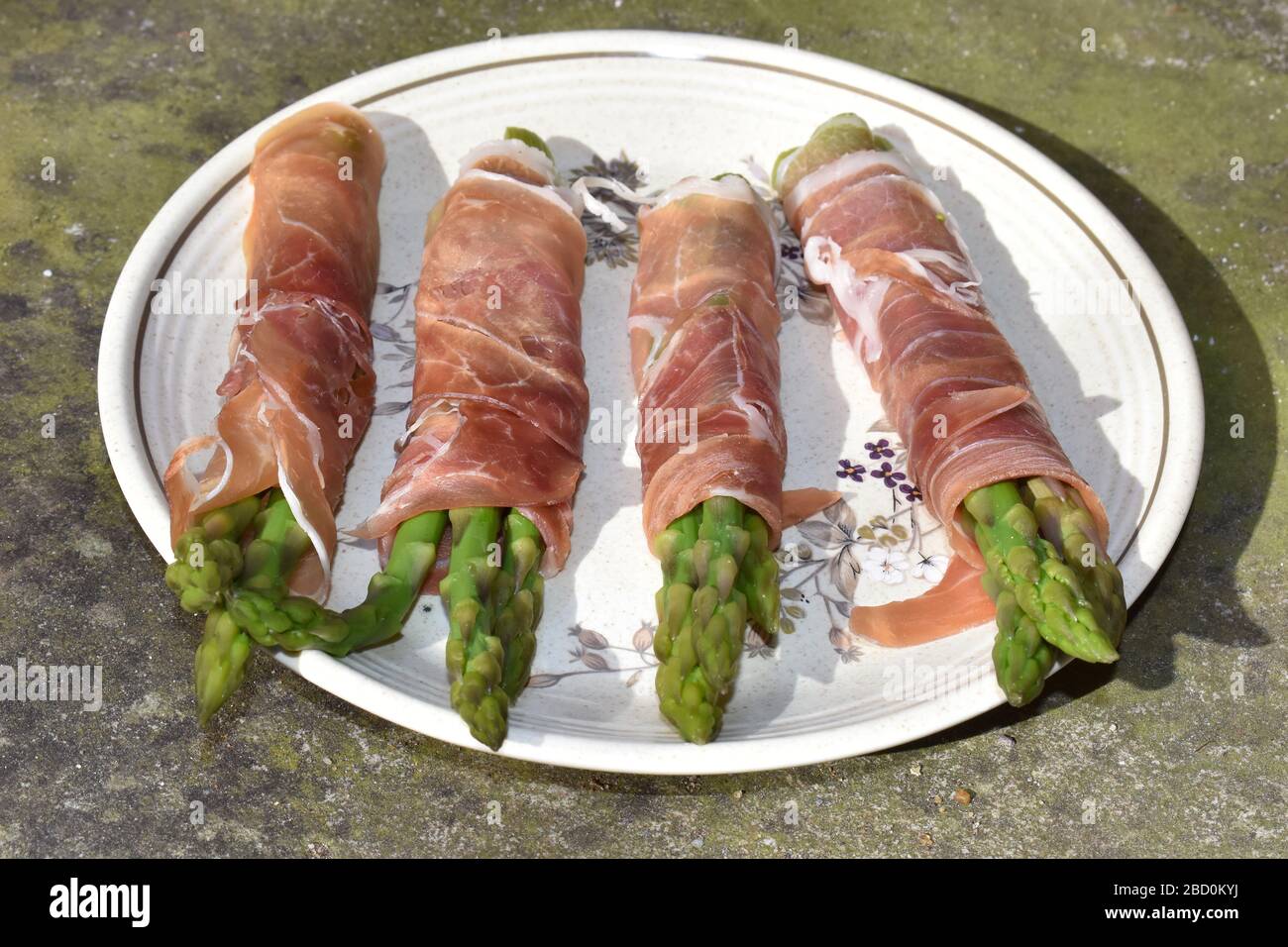 Niedrig karbiger Knoblauchbutter Prosciutto Schinken gewickelter Spargel, der auf den Holzkohlegrill geworfen wird Party Fingerfood einfach und schnell zu Hause zu machen Stockfoto