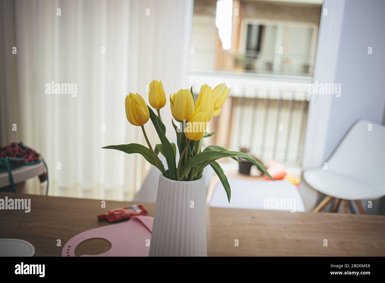 Gelber Blumenstrauß auf weißem Sockel auf einem Hausraum unordentlich Stockfoto