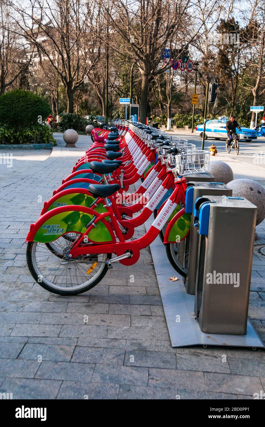 Eine Reihe von Fahrrädern für die öffentliche Nutzung in einem Fahrrad Kostenteilung in Yangzhou Stadt, Provinz Jiangsu, China. Die Menschen benutzen, um eine Karte zu entsperren, das Fahrrad aus dem Stand. Stockfoto