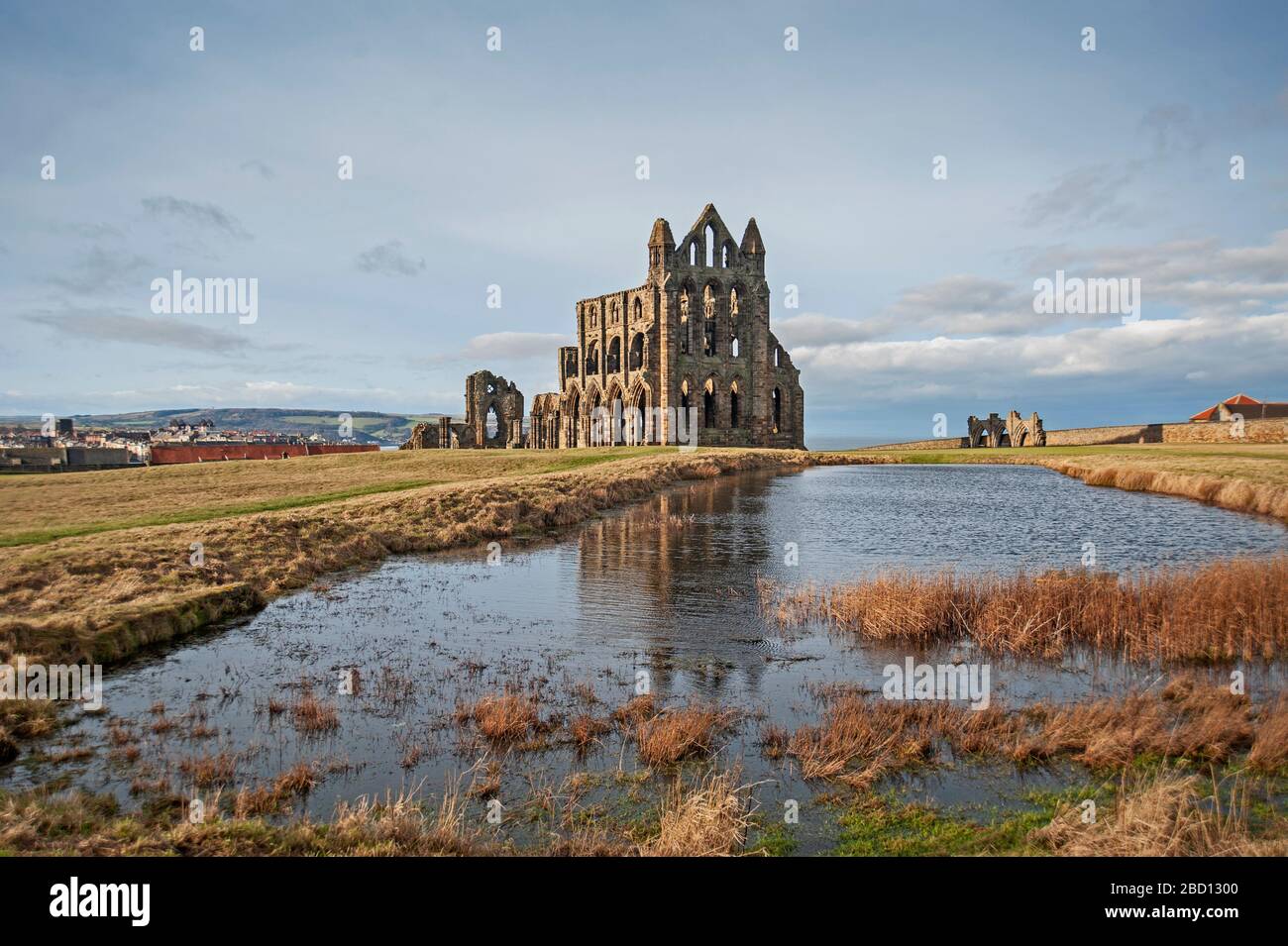 Überreste einer antiken englischen Klosterruine mit Spiegelbild im Wasser des Sees Stockfoto