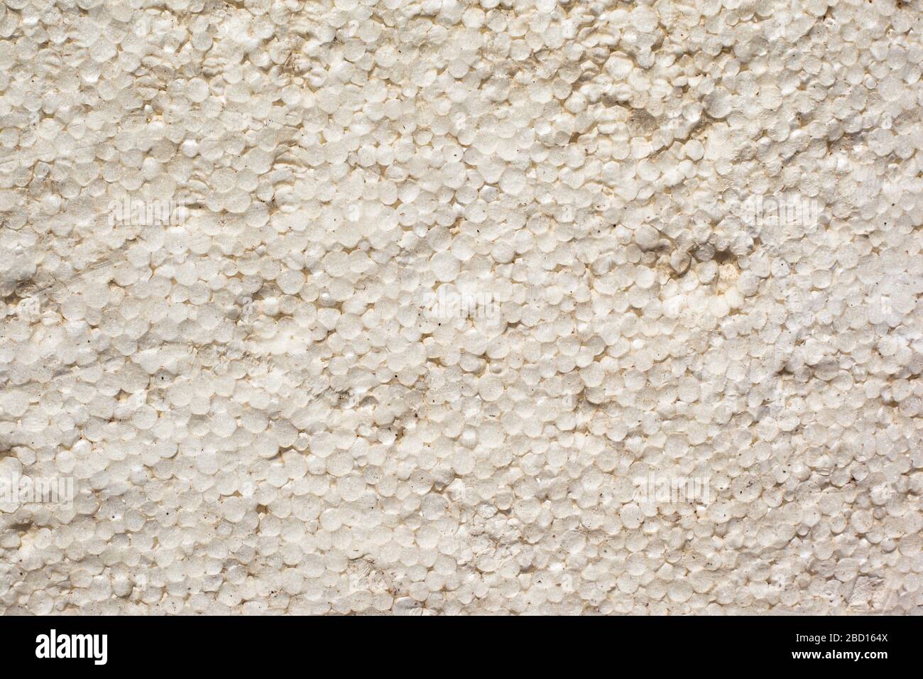 Textur der Fassade schmutzig weißer Styroporhintergrund Nahaufnahme. Stockfoto