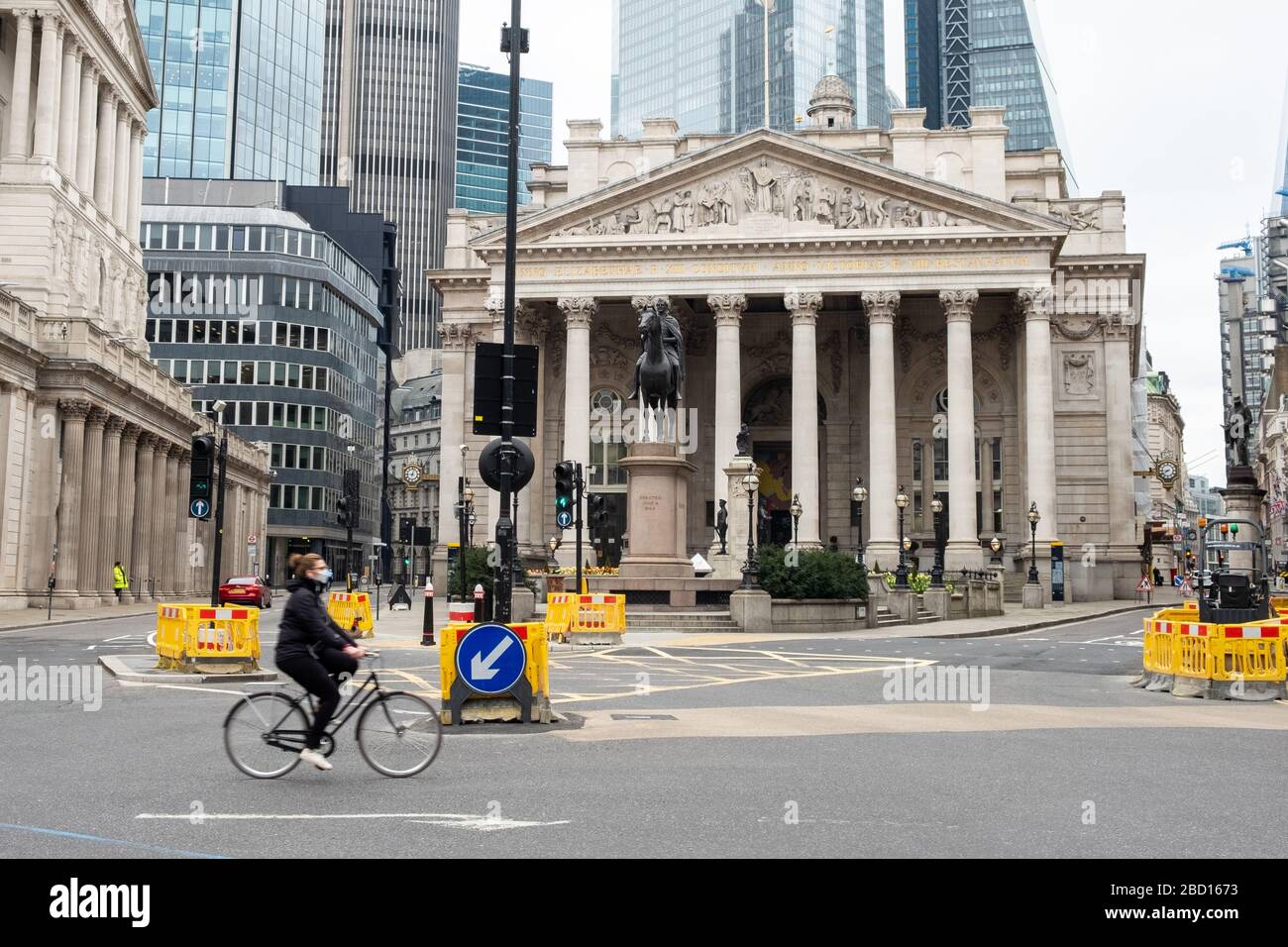 Royal Exchange, London, Großbritannien. März 2020. Ein einsamer Radfahrer, der einen Facemask trägt, geht an der Royal Exchange in der City of London vorbei. Diese verlassenen Straßen wären normalerweise in der Hauptverkehrszeit am Morgen voll von Menschen. Die meisten Menschen haben die Vorschriften der britischen Regierung über die Corona-Virussperre befolgt und sind zu Hause geblieben. Kredit: Tom Leighton/Alamy Live News Stockfoto