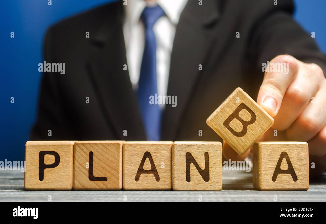Der Geschäftsmann stellt Holzblöcke mit den Worten Plan A und B. Strategieplanung. Unternehmensleitung. Wählen Sie die richtige Lösung. Backup-Plan. Optionen an Stockfoto