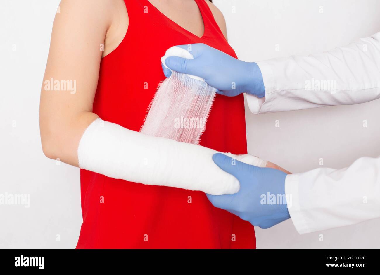 Der Chirurg umschließt den Arm mit einem Verband eines Mädchens, dessen Spregen und Schmerzen im Arm, Deformierung der Arthrose, Bänderriss Stockfoto