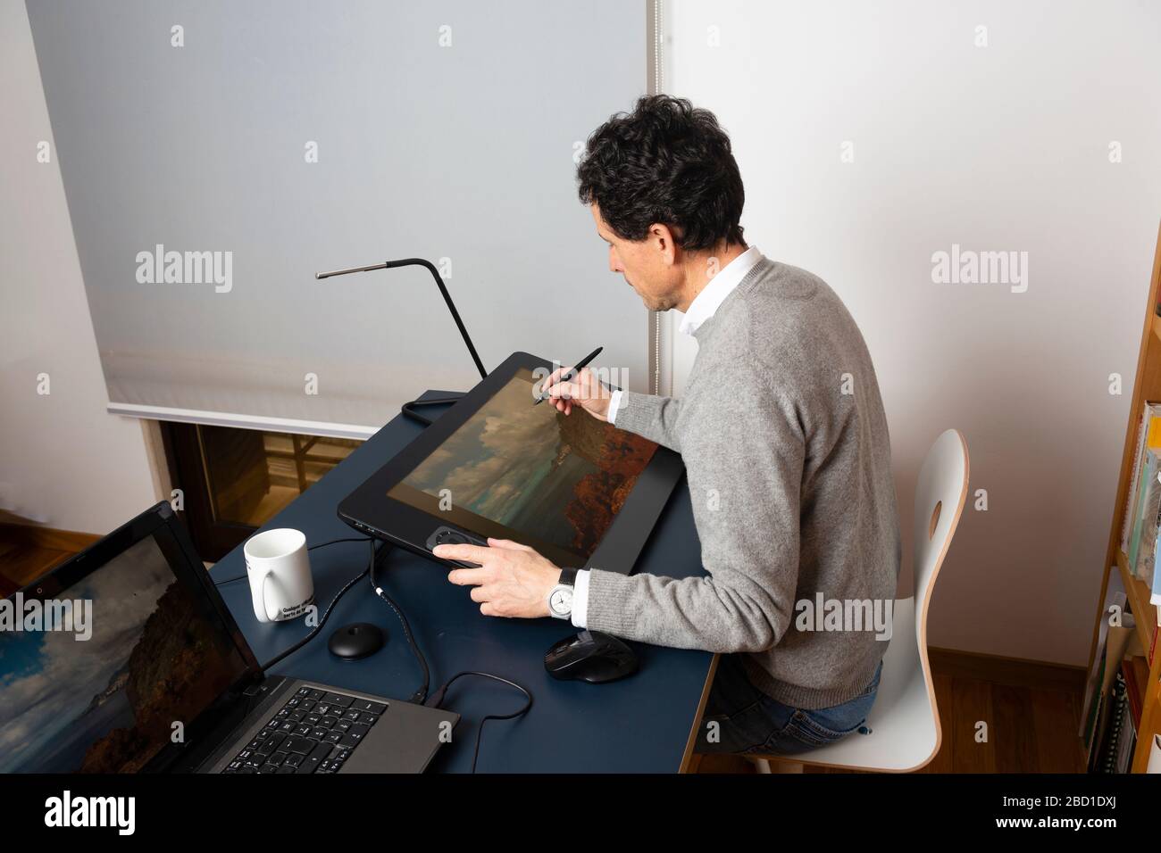 50-jähriger Mann, der zu verschiedenen Tageszeiten zu Hause arbeitet Stockfoto