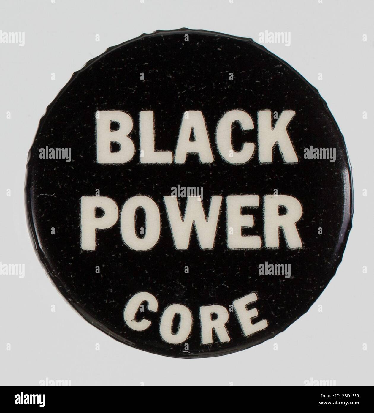 Rückklemmtaste für CORE und Black Power. Eine schwarze Rücktaste mit weißem Text, der in der Mitte zentriert ist. Der Text lautet: [BLACK POWER / CORE]. Entlang der Außenkante, an der das Schaltflächenbild auf die Metallunterseite trifft, ist weißer Text abgeschnitten und unleserlich. Rückklemmtaste für CORE und Black Power Stockfoto