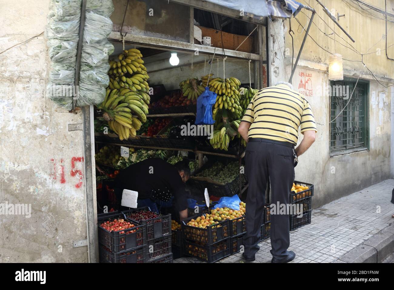 Beirut, Libanon - 9. Juni 2017: Alter Mann in lässiger Kleidung kauft Früchte in einem Straßenladen. Stockfoto