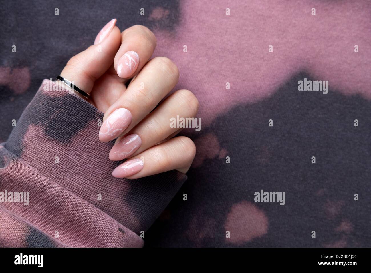 Manikured Woman's Hand in trendigen pinkfarbenen Hoodie. Stockfoto