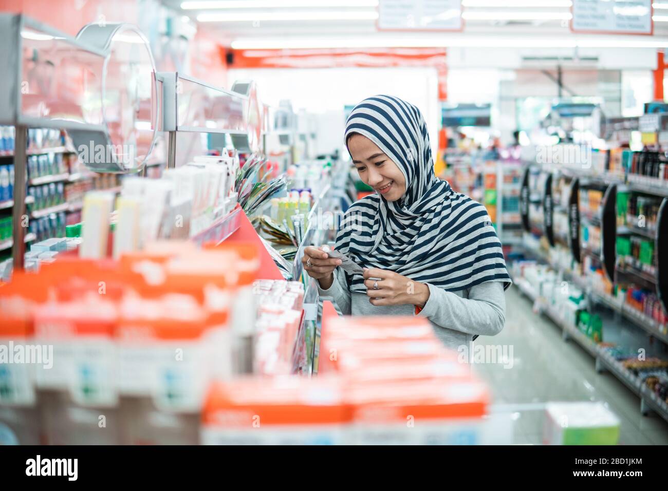 muslimische asiaten kaufen im Supermarkt einkaufen und etwas Produkt kaufen Stockfoto