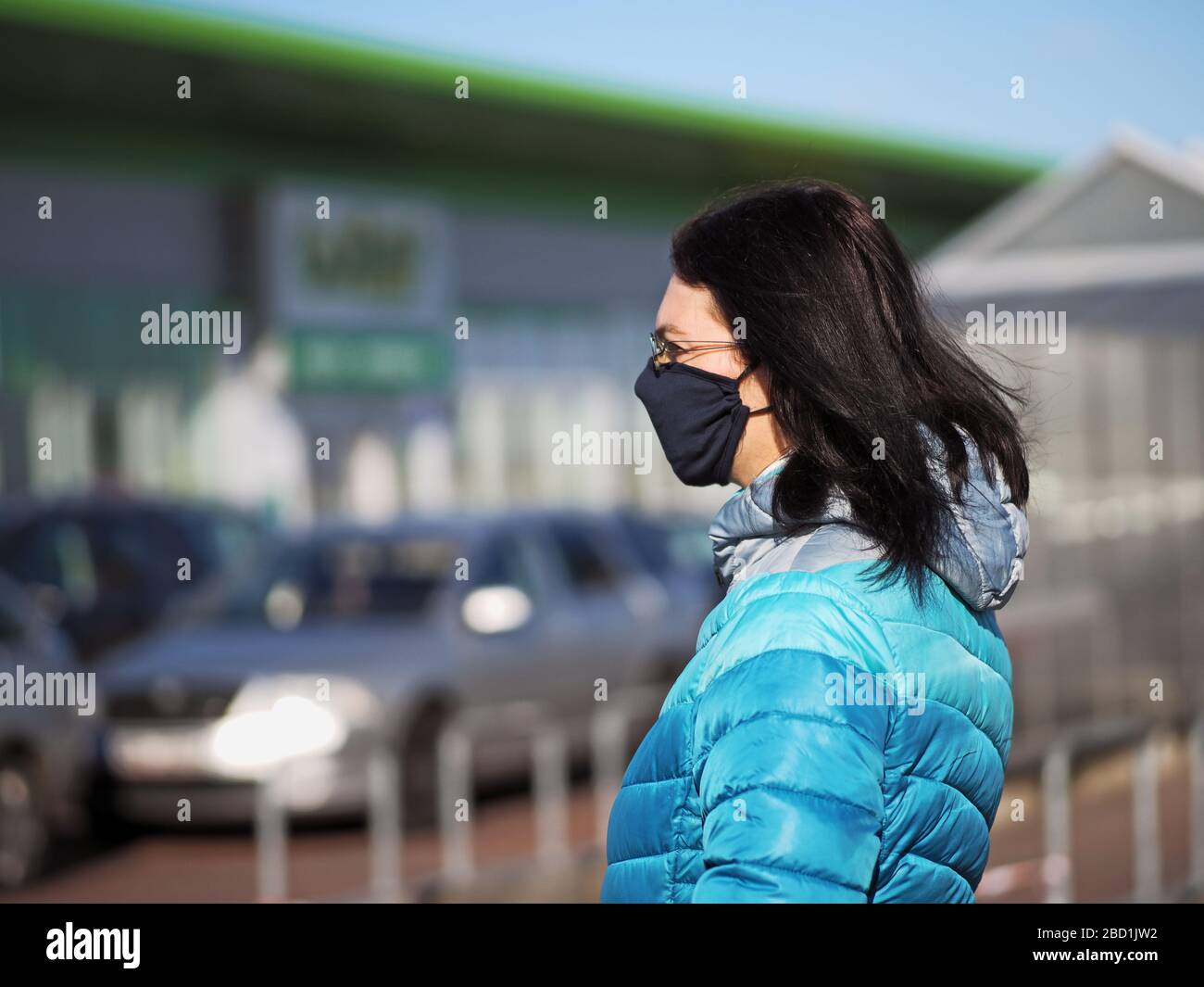 Frau mit Schutzmaske im Gesicht kauft während einer Coronavir-Pandemie in einem Einkaufszentrum Stockfoto