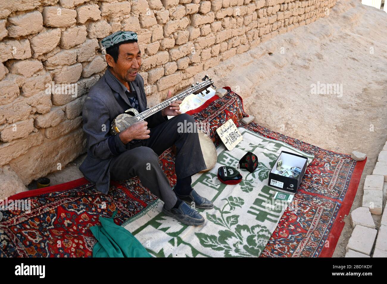 Uyghur man spielt eine Rawap, traditionelle Uyghur Laute, in Gaochang, ruinierte Silk Road City, Xinjiang, China, Asien Stockfoto
