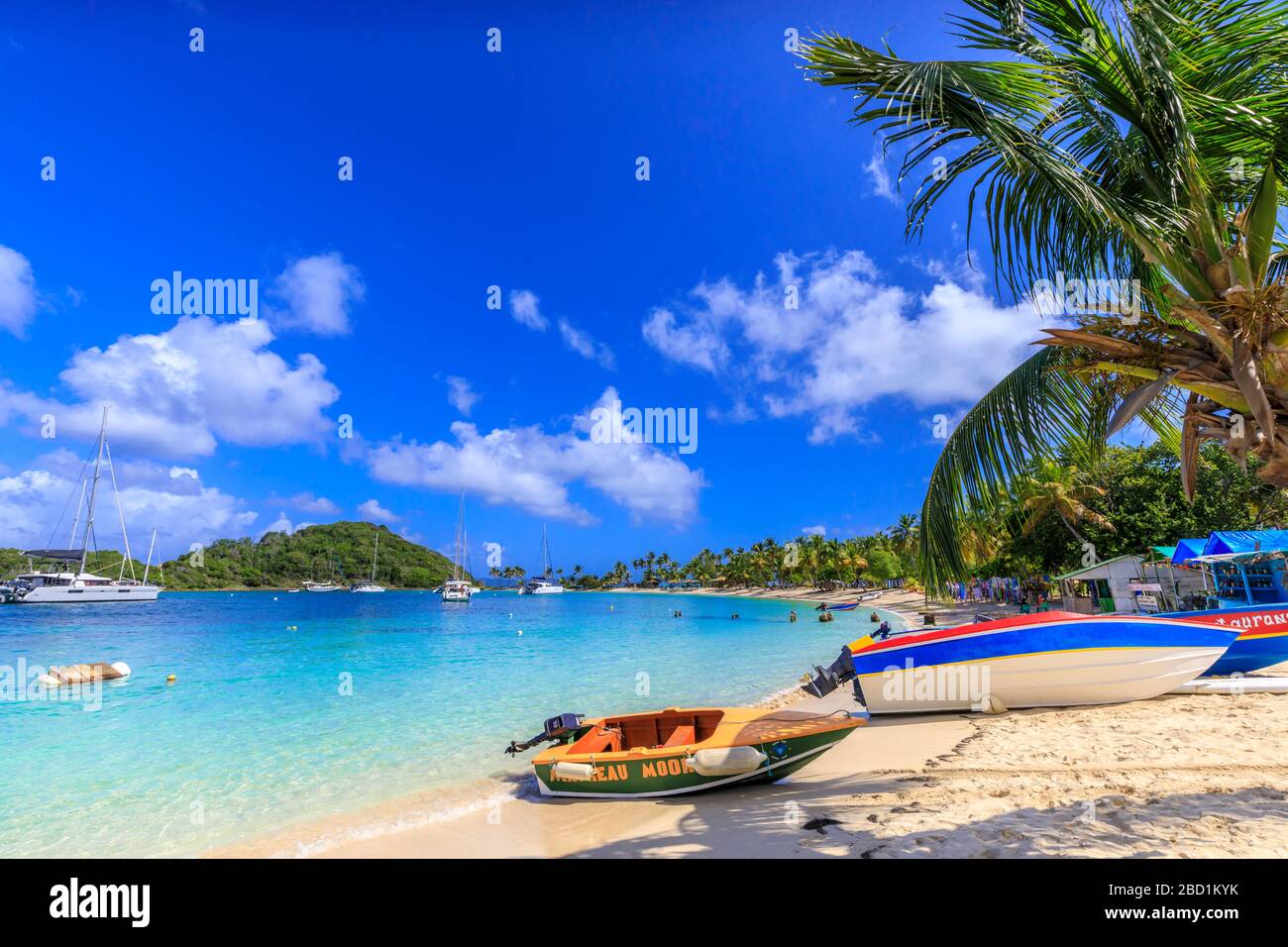 Buntes Boot, weißer Sandstrand, türkisfarbenes Meer, Palmen, Jachten, Saltwhistle Bay, Mayreau, Grenadinen, St. Vincent und die Grenadinen, Karibik Stockfoto