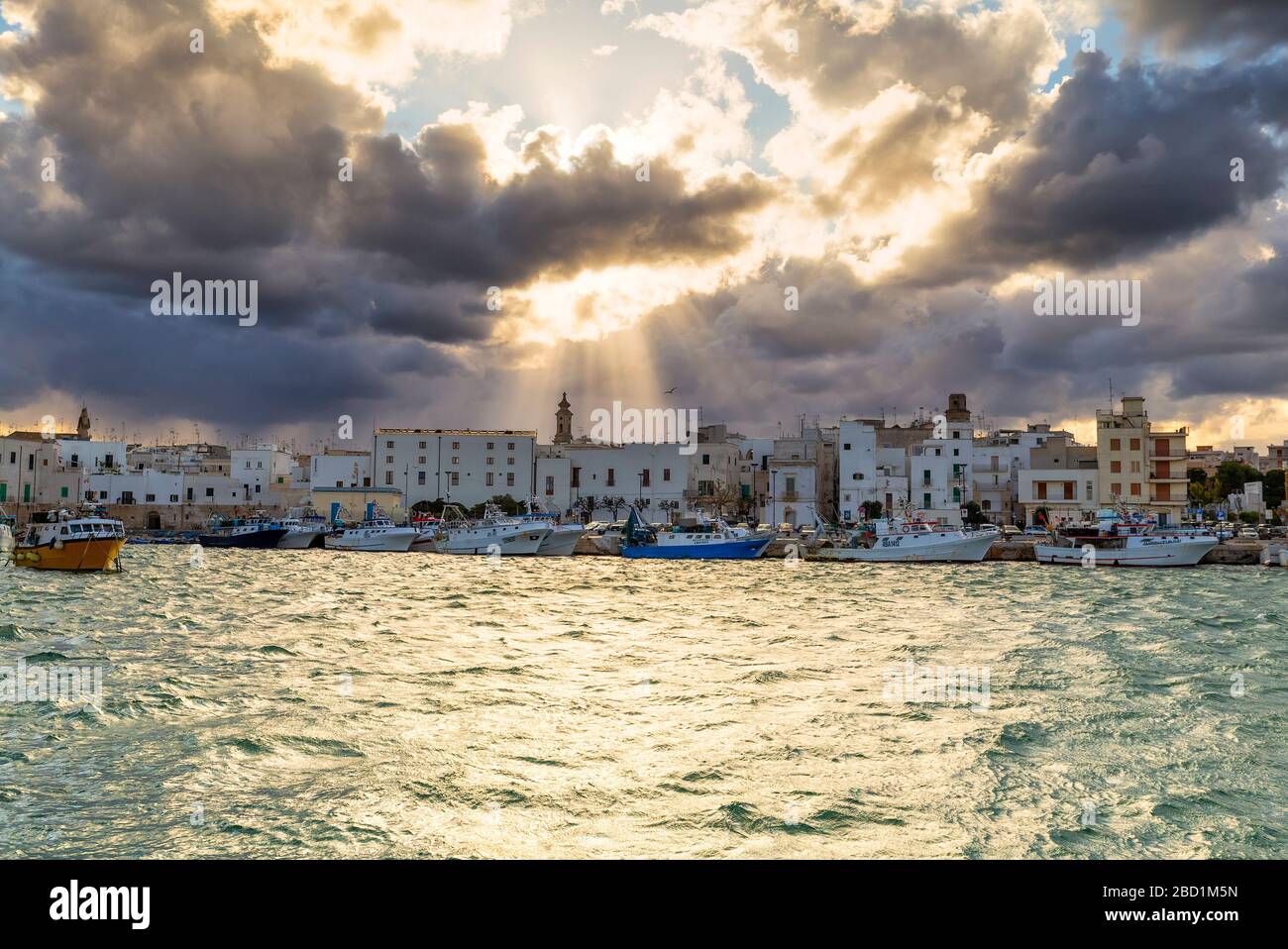 Altstadt, beleuchtet von Sonnenstrahlen, die zwischen Wolken filtern, Monopoli, Apulien, Italien, Europa Stockfoto