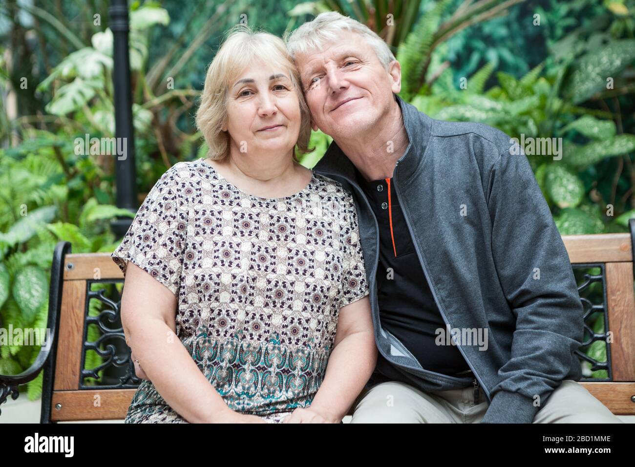 Fröhliches und lächelndes Familienporträt mit Mann und Frau, das auf der Wange sitzt, um sich zu überwehen. Kaukasische Menschen Stockfoto