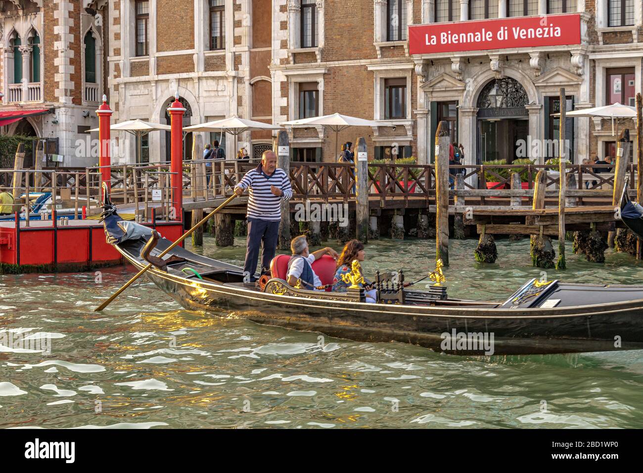 Ein Paar nimmt eine Gondelfahrt in der späten Nachmittagssonne entlang des Canal Grande, Venedig, Italien Stockfoto