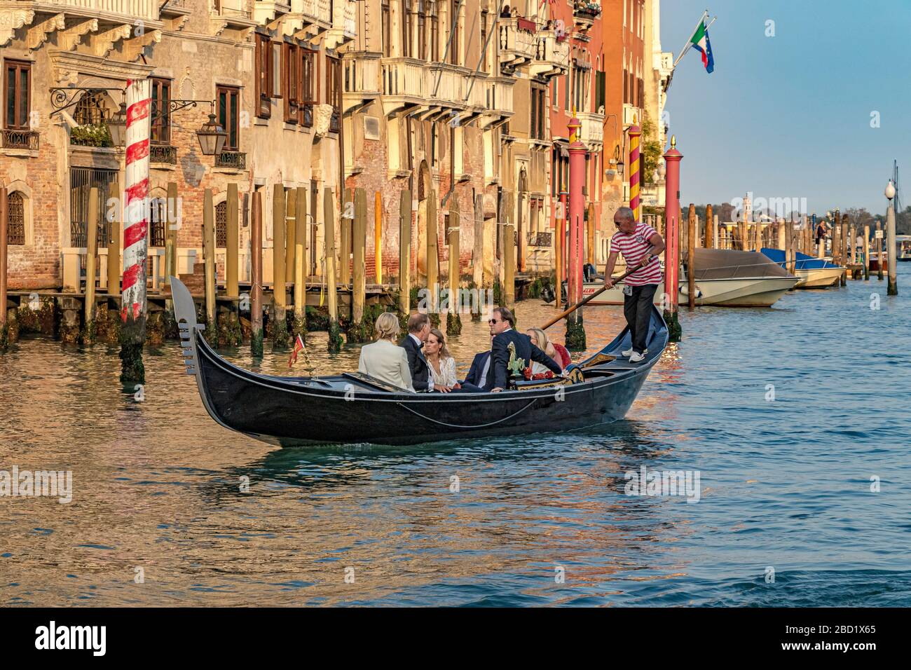 Eine Hochzeitsgesellschaft, die eine Gondelfahrt in der späten Nachmittagssonne auf dem Canal Grande in Venedig, Italien, Unternehmen kann Stockfoto