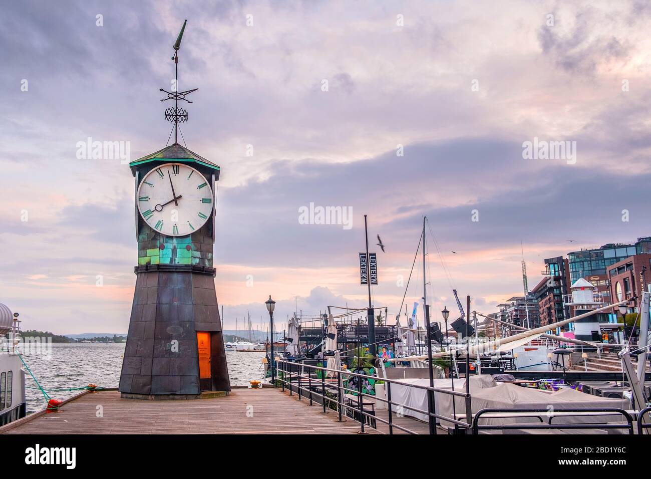 Oslo, Ostlandet/Norwegen - 2019/09/02: Modernes Aker Bryggge-Viertel von Oslo mit historischem Uhrturm am Pier des Oslofjorder Ufers Stockfoto