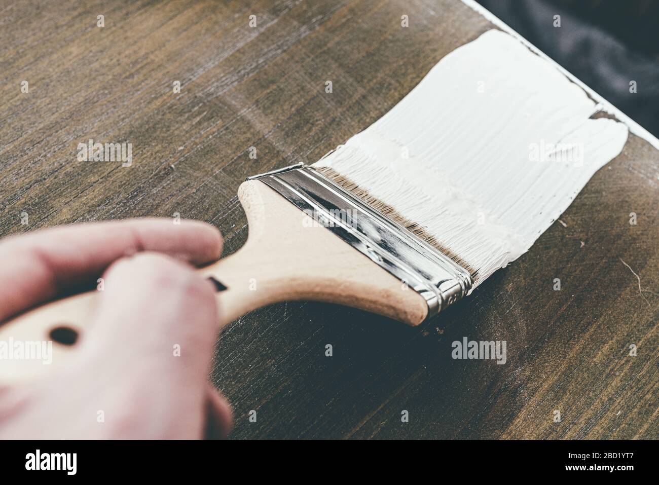 Nahaufnahme mit Bürste zum Lackieren von Holzmöbeln mit weißer Farbe Stockfoto