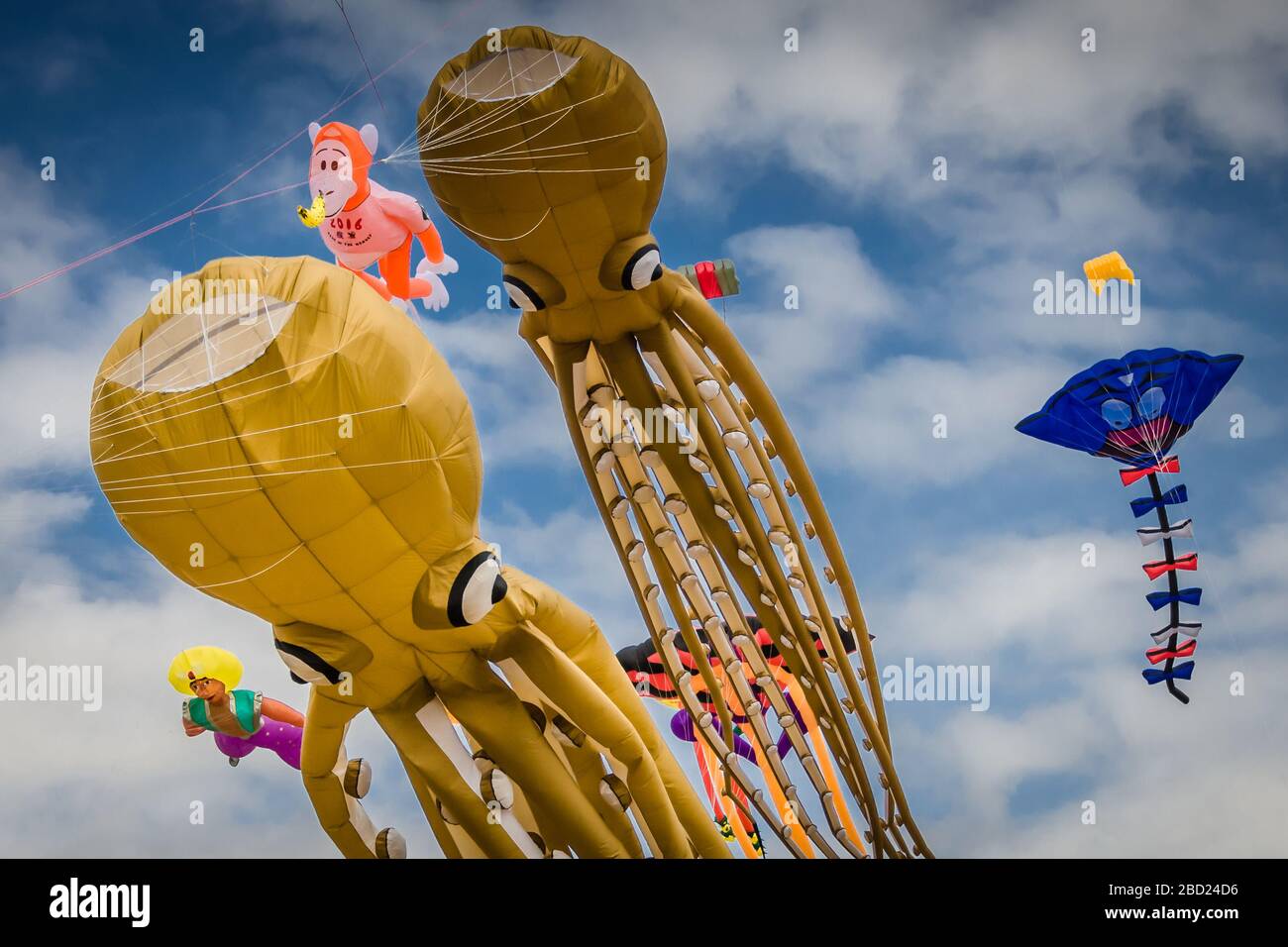 Riesige fliegende Kraken-Drachen beim Summer Southsea Kite Festival in Portsmouth, Großbritannien mit blauem Himmel und Wolken im Hintergrund Stockfoto