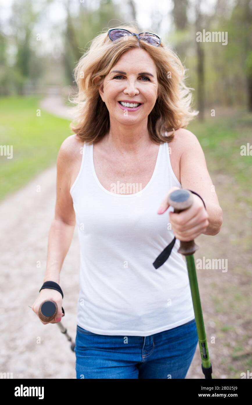 Eine attraktive Frau mit einem sympathischen Lachen in der Natur beim Gehen Stockfoto