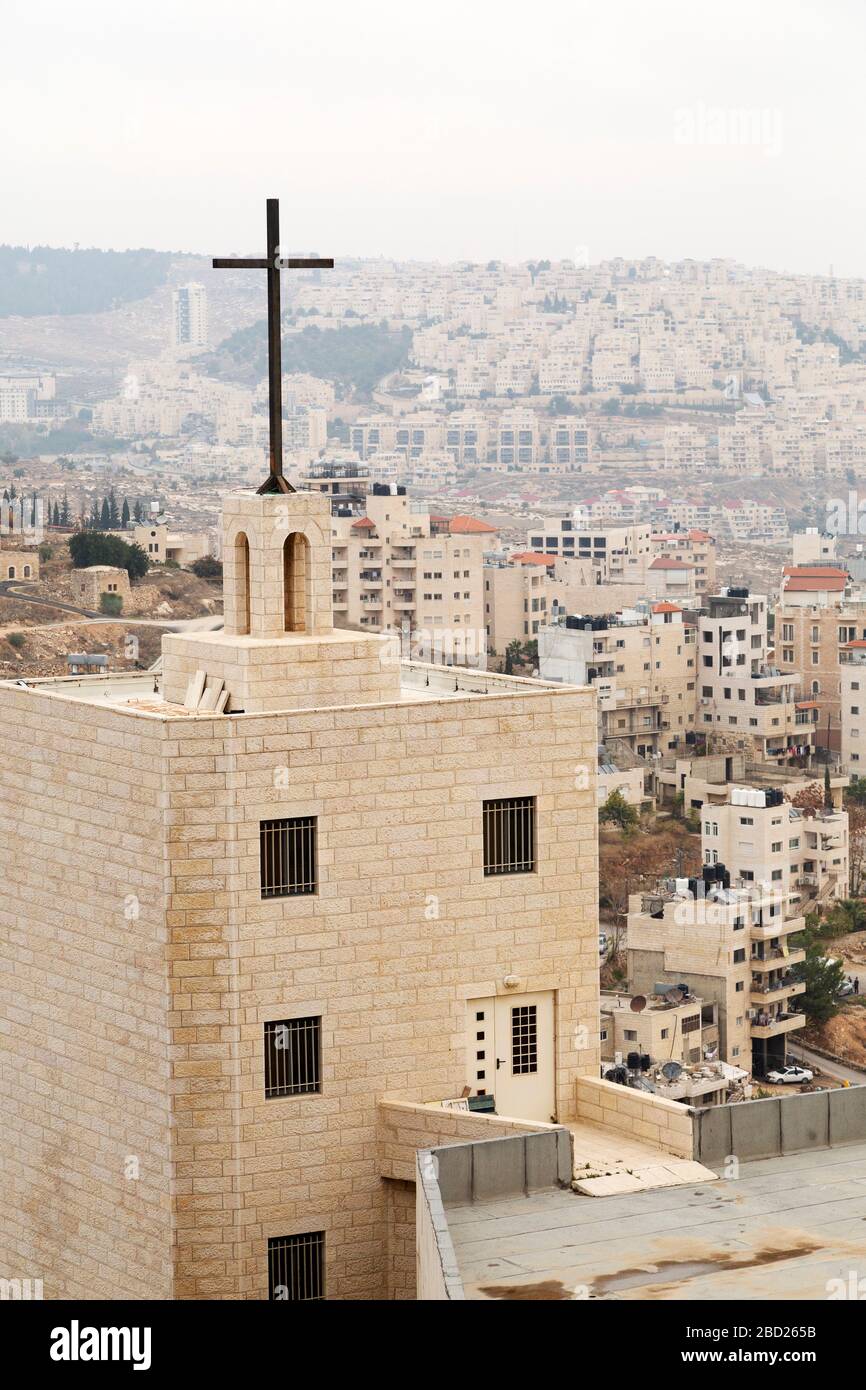 Kirche von der Manger Street in Bethlehem, Israel. Das Gebäude wird von einem Kruzifix überragt. Stockfoto
