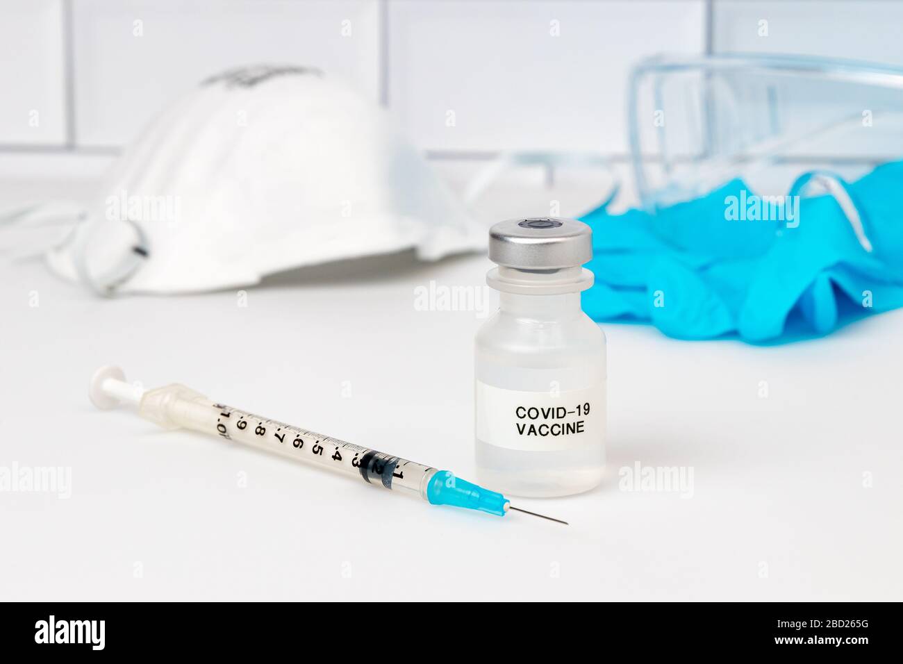 Konzept des Covid-19 Coronavirus-Impfstoffs. Medizinische Fläschchen, Nadelspritze, medizinische Untersuchungshandschuhe, Schutzbrille und N95 Atemschutzmaske Stockfoto