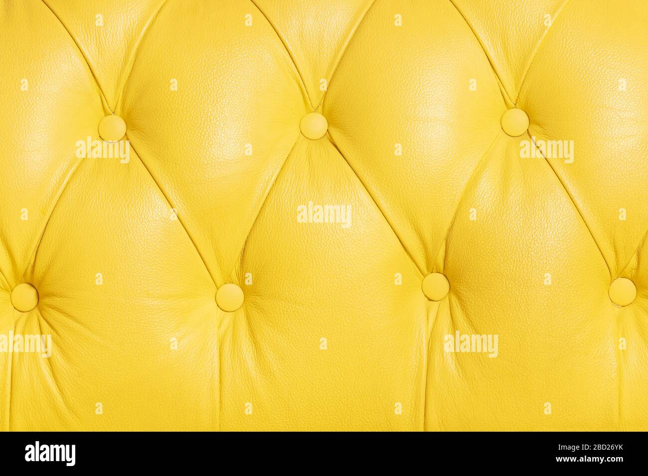 Gelbes Hintergrundmuster eines mit Knopf versehenen Ledersofas aus chesterfield Stockfoto
