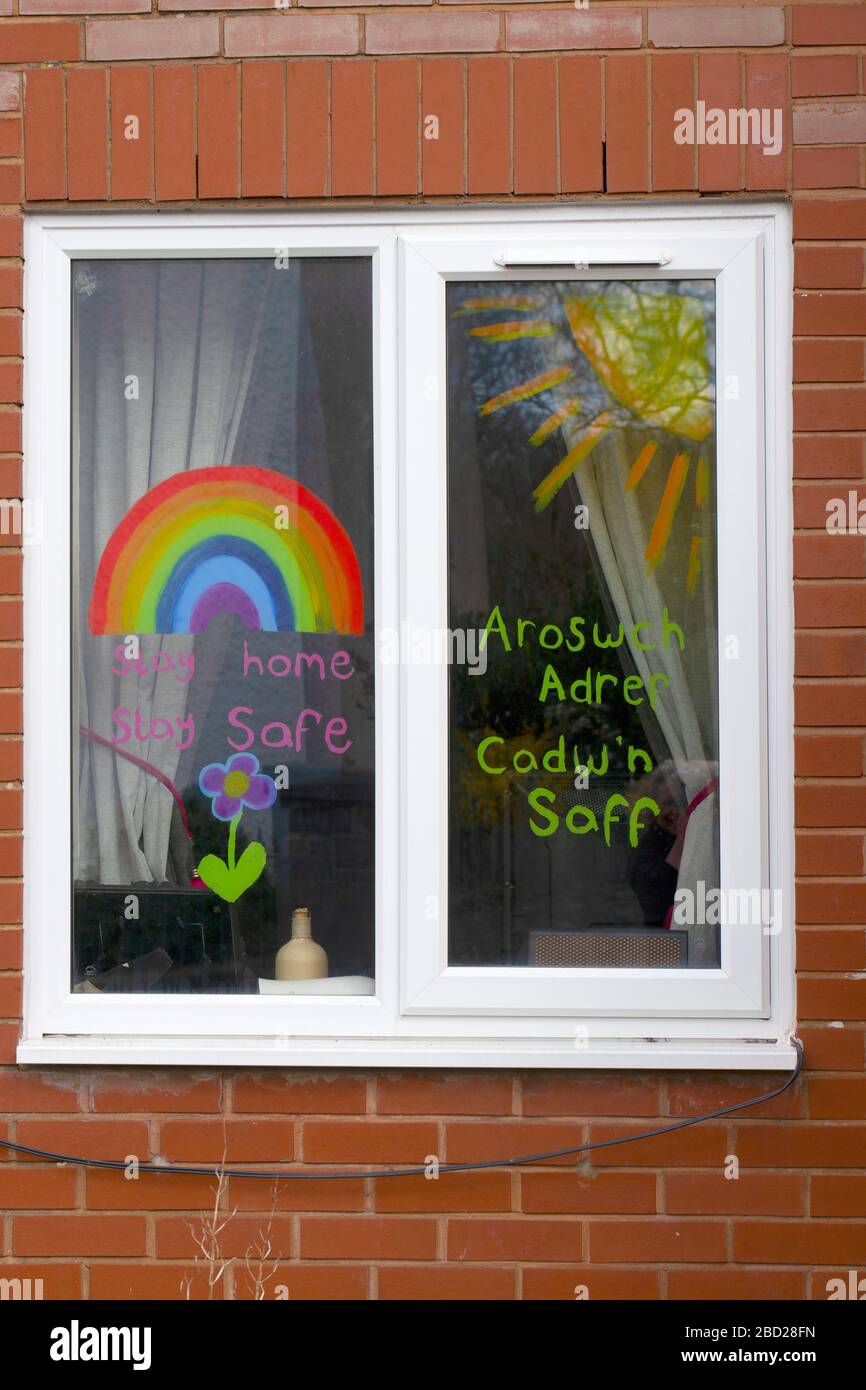 Childs Zeichnung eines Regenbogens mit Dankesbotschaften für NHS-Mitarbeiter und Schlüsselarbeiter in einem Fenster eines Hauses während der Regierung auferlegten Lockdown in Wales Stockfoto