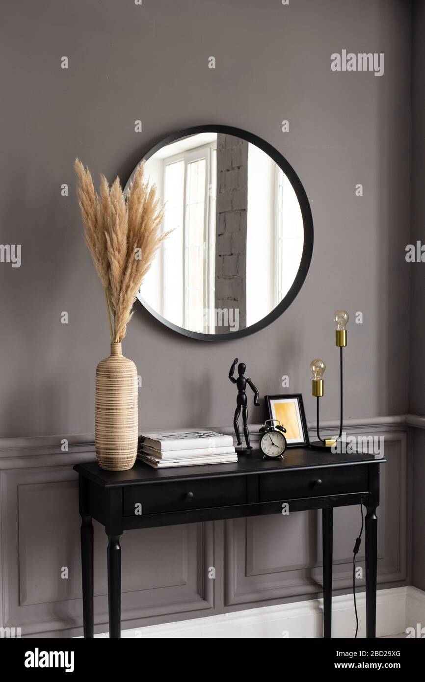 Konsole mit Spiegel auf dem Hintergrund einer grauen Wand in einem modernen Interieur Stockfoto
