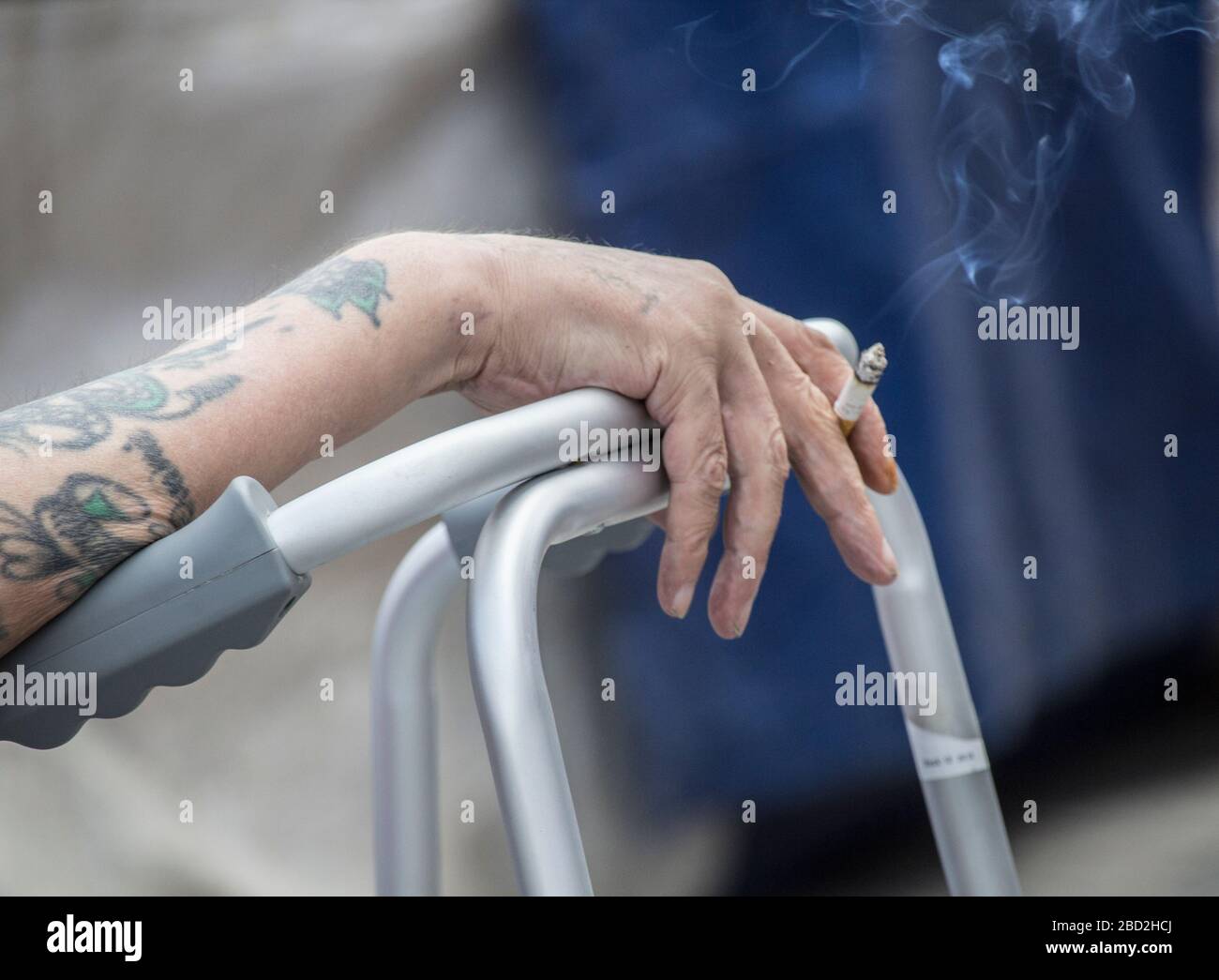 Mann mit Laufrahmen, der im Pub-Garten raucht. UK Stockfoto