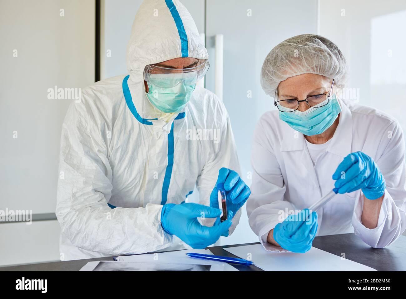 Forscher arbeiten an Covid-19-Medikamenten und Impfungen in Schutzkleidung im Labor während einer Coronavirus-Epidemie Stockfoto
