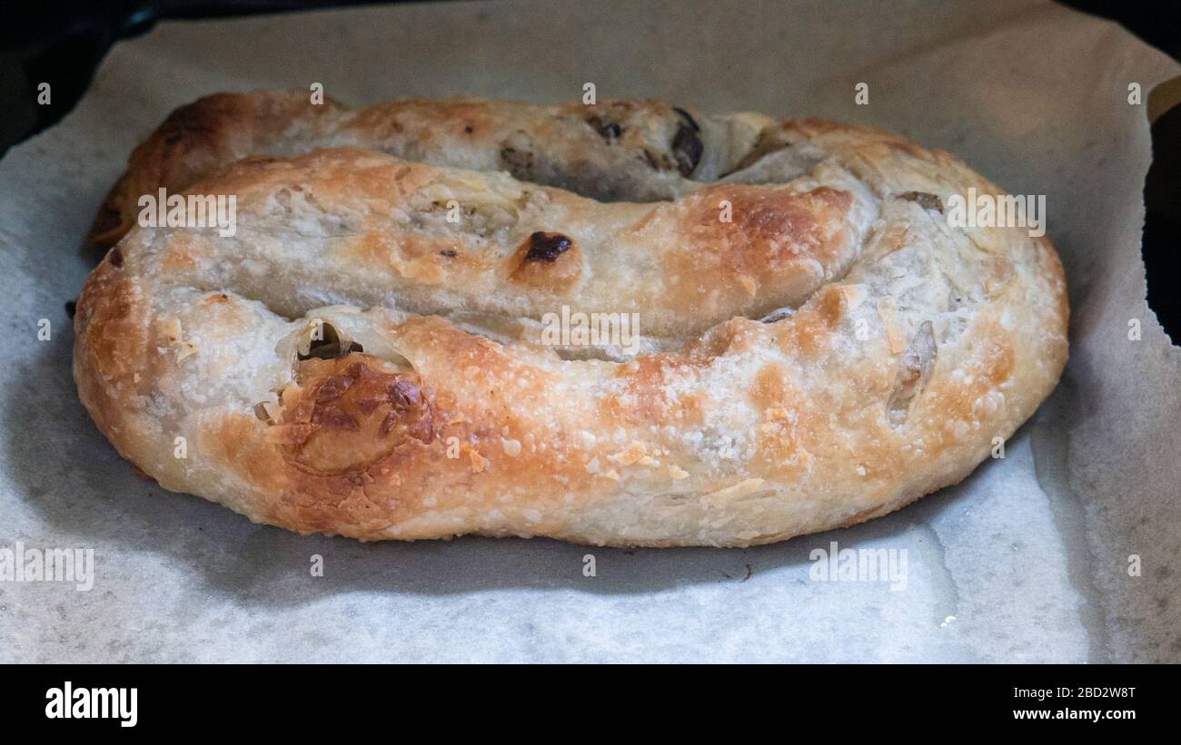 Vertuta - Bürettenrolle auf weißem Pergamentpapier. Leckeres und zartes Gebäck auf weißem Backpapier. Stockfoto