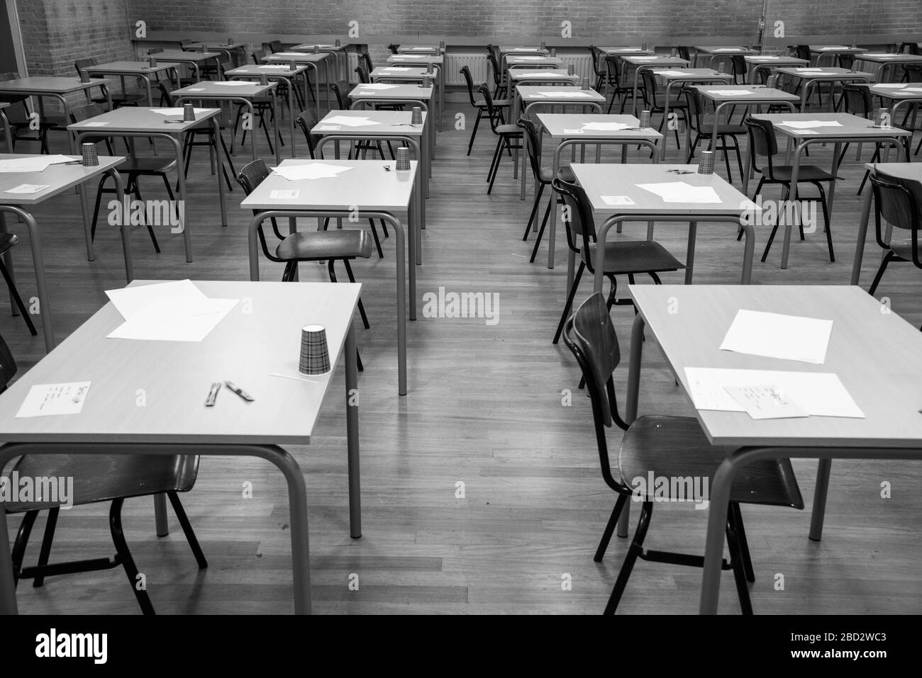 Reihen leerer Tische und Stühle im Untersuchungsraum an der Highschool in Schwarz-Weiß Stockfoto
