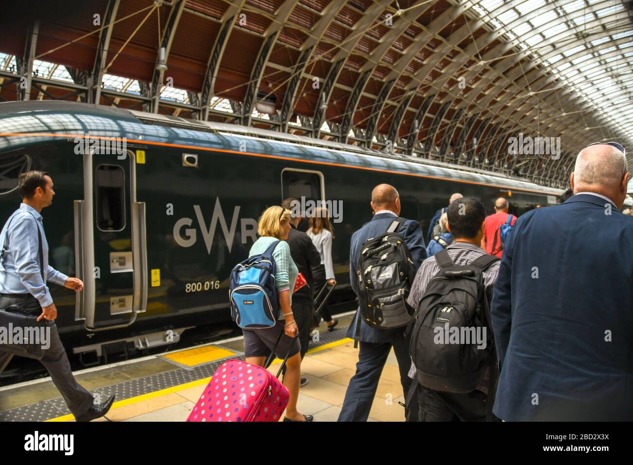LONDON, ENGLAND - JULI 2018: Menschen, die auf einem Bahnsteig am Bahnhof London Paddington spazieren, um nach Bekanntwerden der Bahnsteignummer einen Zug zu nehmen. Stockfoto