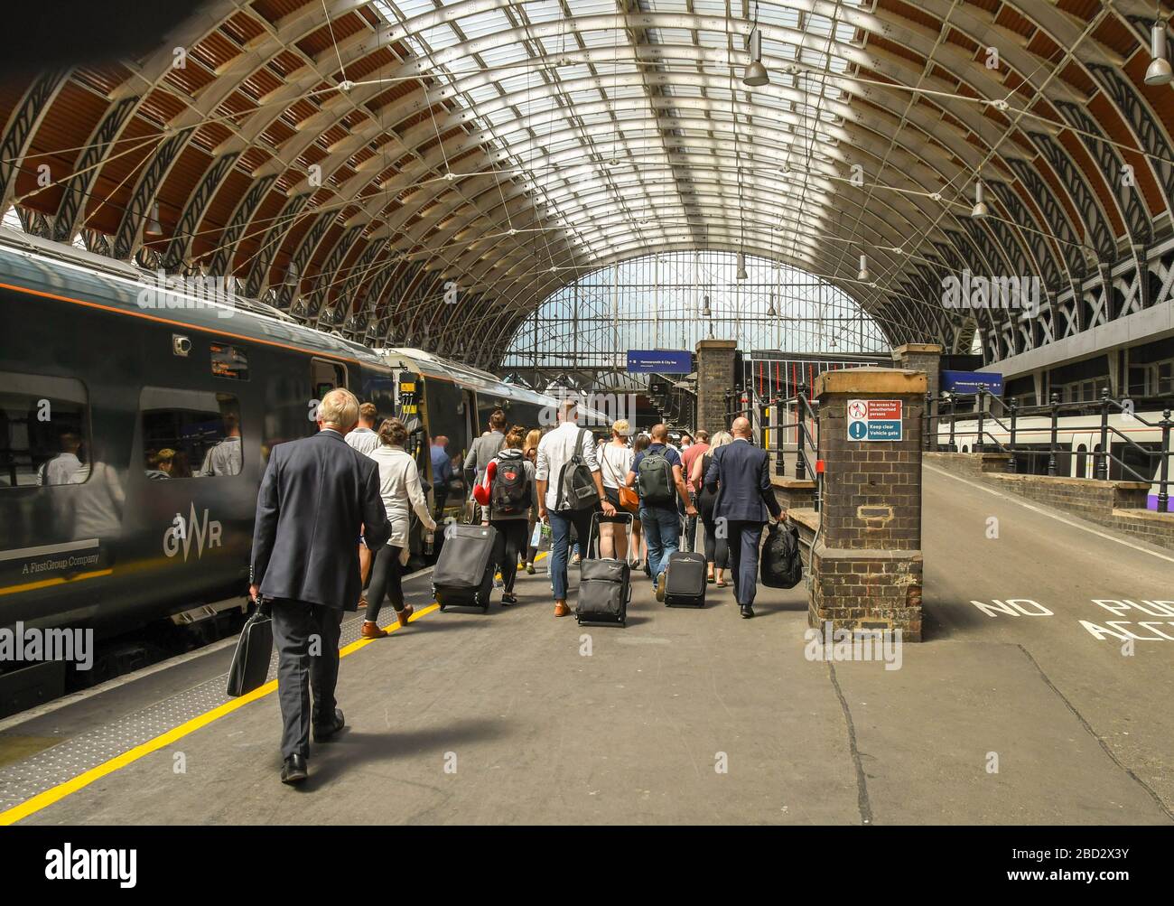 LONDON, ENGLAND - JULI 2018: Weitwinkelansicht der Menschen, die auf einem Bahnsteig am Bahnhof London Paddington gehen, um einen Zug zu nehmen Stockfoto