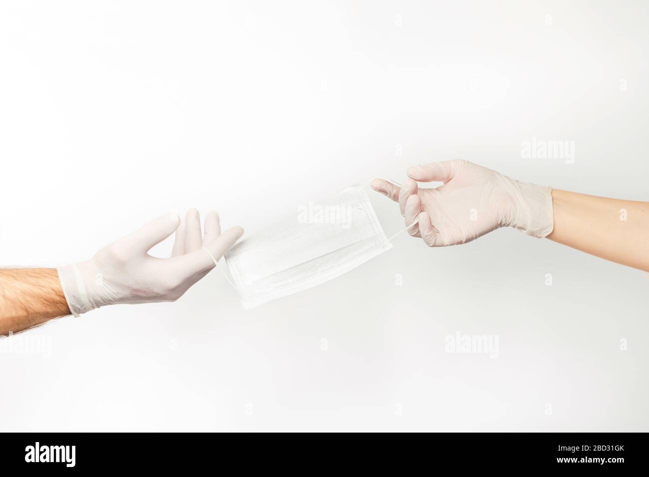 Hände für Männer und Frauen in Latexhandschuhen mit einer medizinischen Maske. Stockfoto
