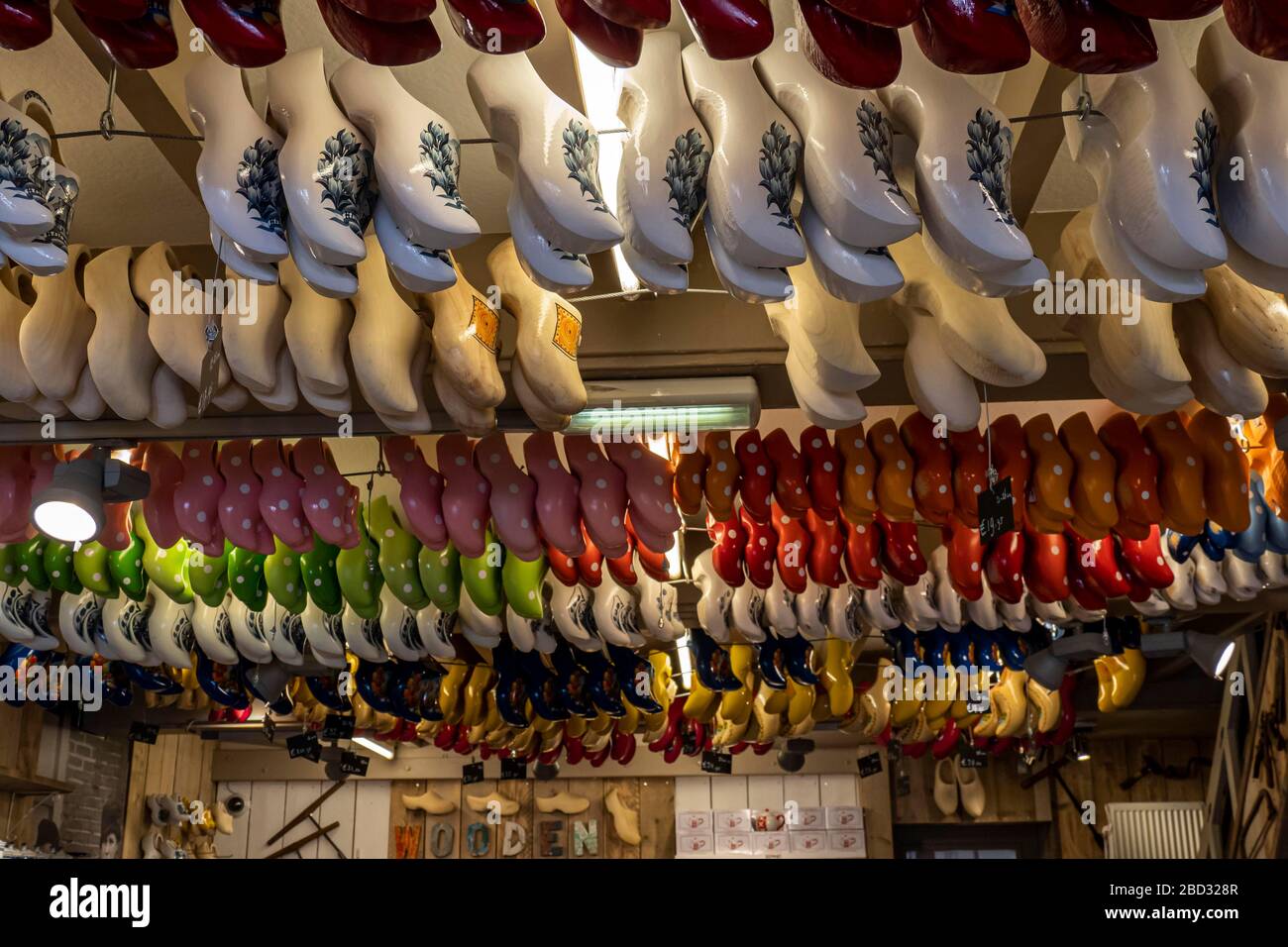 Traditionell farbenfroh bemalte holländische Clogs, die in einer Clogs-Werkstatt, Volendam, Nordholland, Niederlande, an der Decke hängen Stockfoto