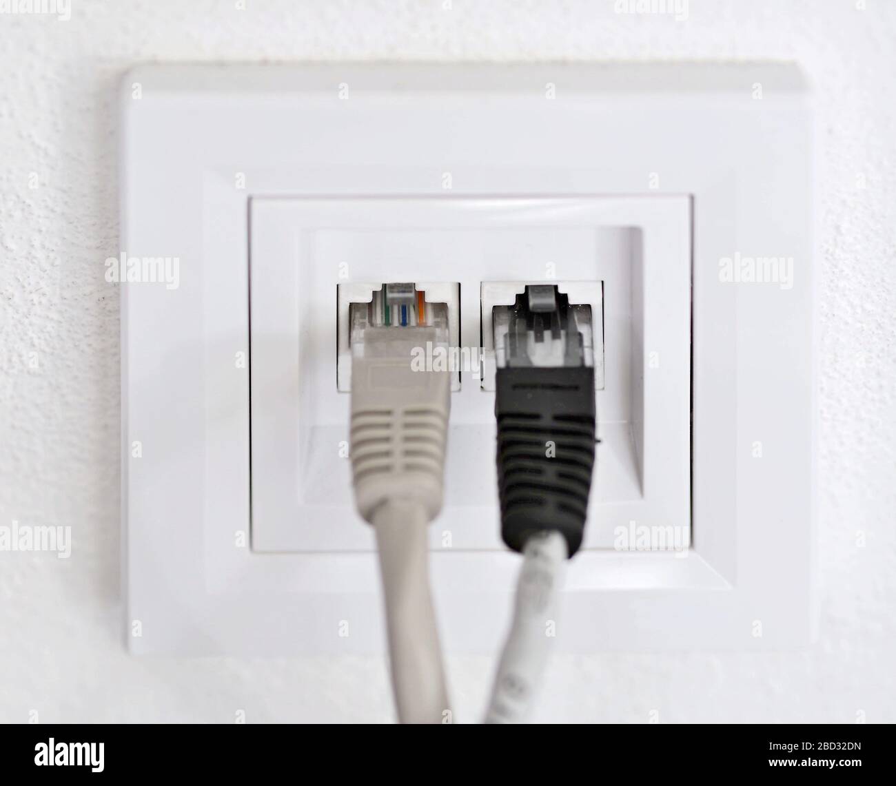 Steckdosen mit Internetkabel an weißer Wand, Nahaufnahme. Stromversorgung  Stockfotografie - Alamy