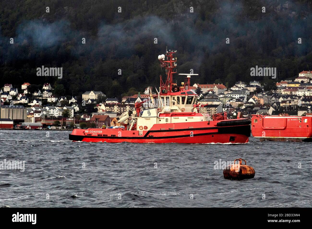 Ein grauer und regnerischer Tag. Schleppboot BB Coaster hat gerade die Unterstützung eines Kreuzfahrtschiffs vom Hafen von Bergen, Norwegen, abgeschlossen Stockfoto