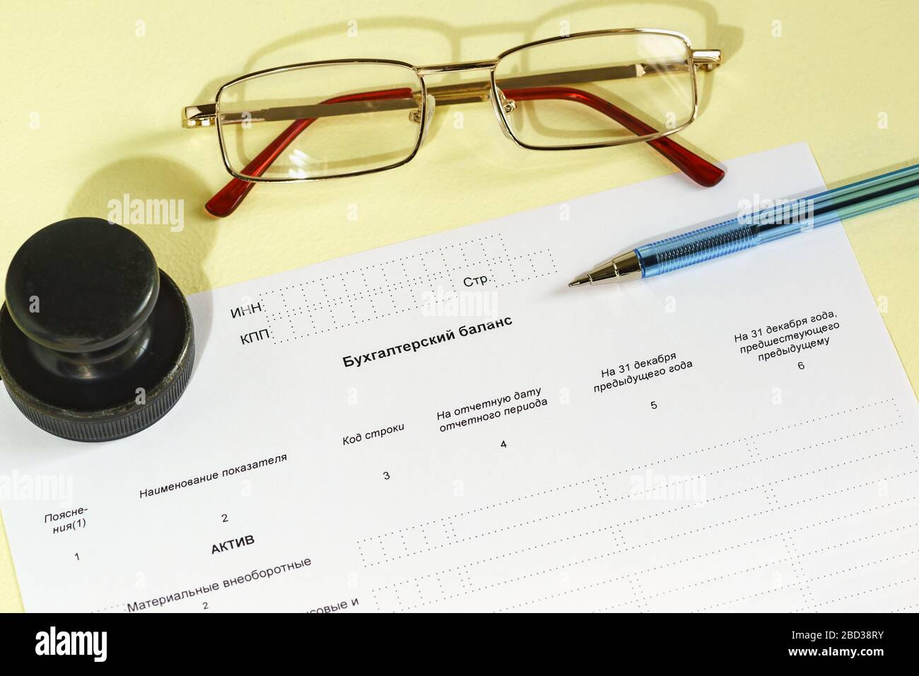 Registrierung des Berichtsdokuments, Druck, Brille und Stift auf dem Tisch. Text in russischer 'Bilanz' Stockfoto