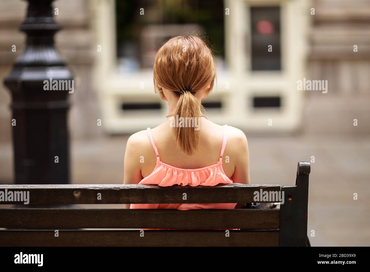 Junge Frau auf einer Bank sitzen Stockfoto